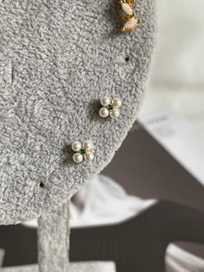 Broquel flor perla con cristal verde